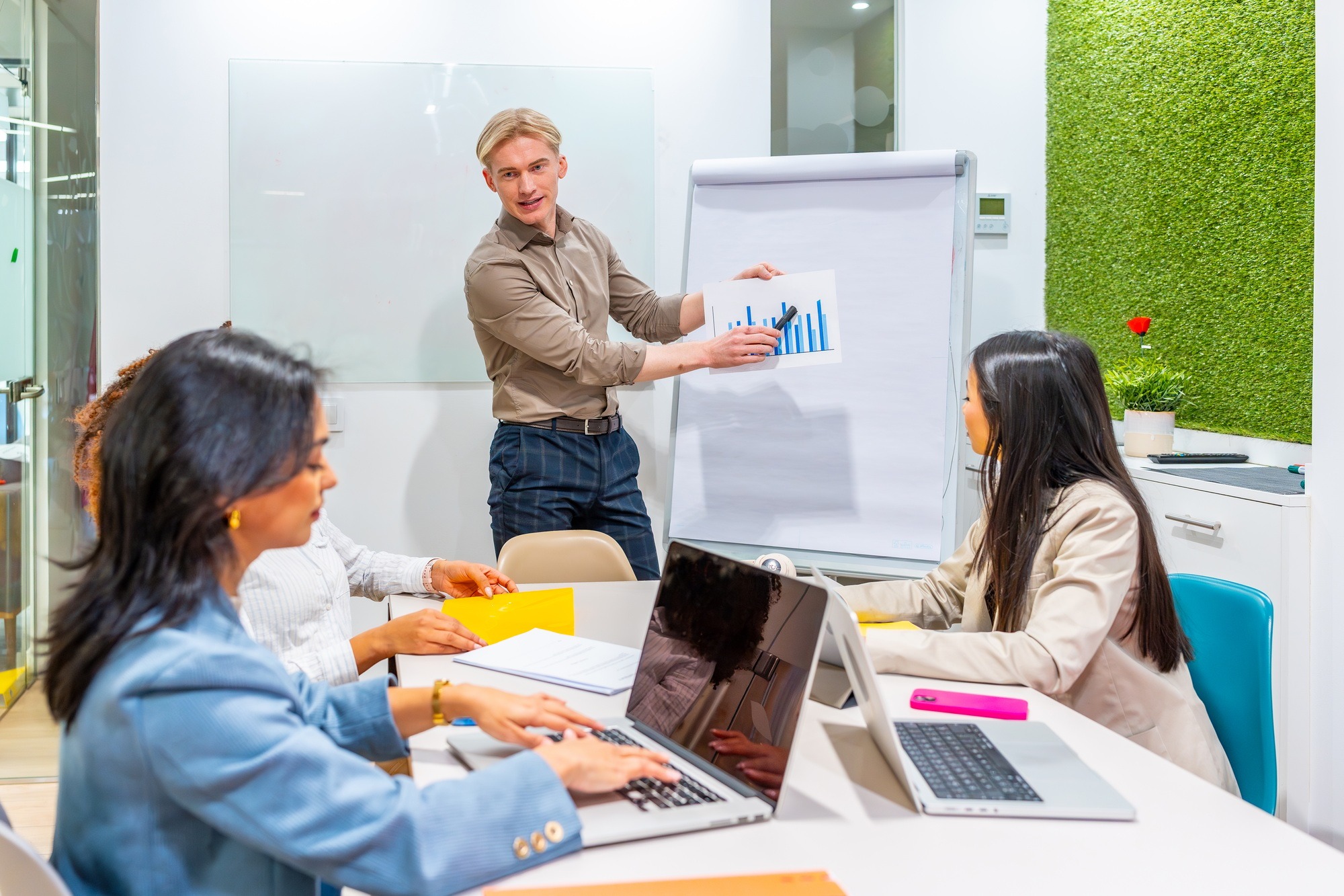 Managers presenting growth strategies on flip chart in coworking office